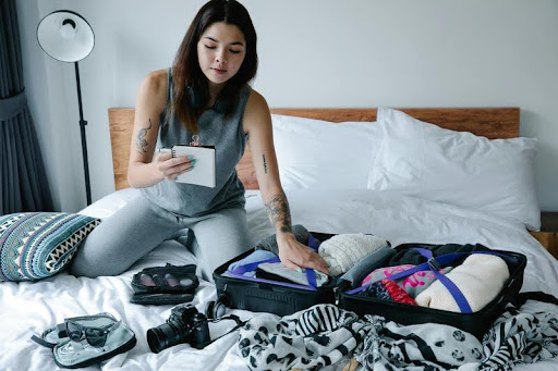 Woman packing a suitcase for vacation at home