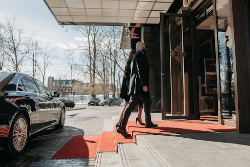 Man checking in at a modern hotel front desk with suitcase