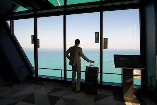 Man standing in airport with suitcase during a work trip