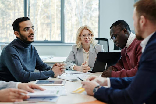 Employer speaking with employees during a team meeting.