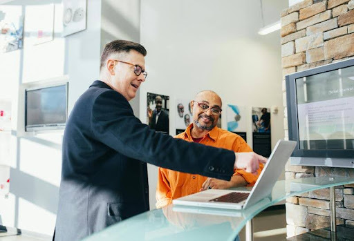 Man pointing at a laptop screen during a marketing strategy session