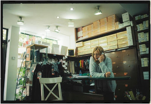 Woman working behind the counter in a retail store.
