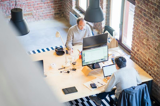 Two people working together at a desk in a modern office.