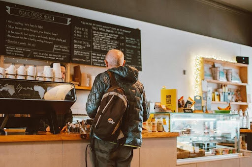 Customer standing at a counter speaking with a business owner