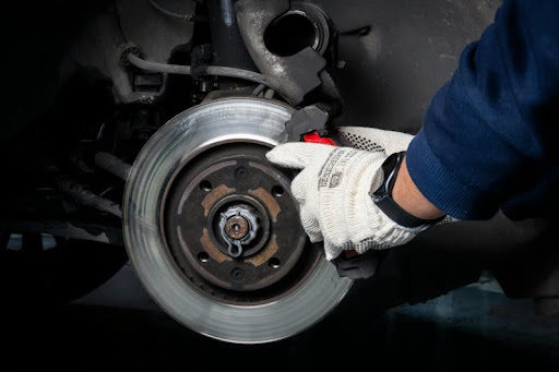 Mechanic performing brake maintenance on a car in a workshop