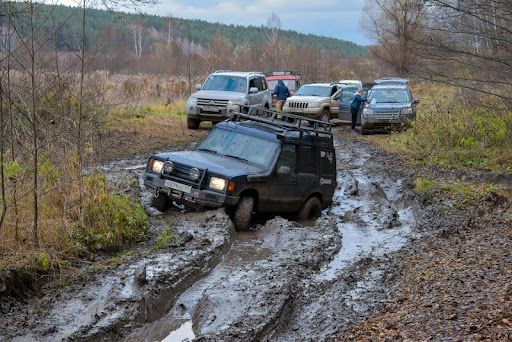 Car stuck in deep mud on a rural dirt road