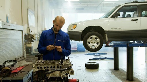 Mechanic inspecting a car engine in a repair shop
