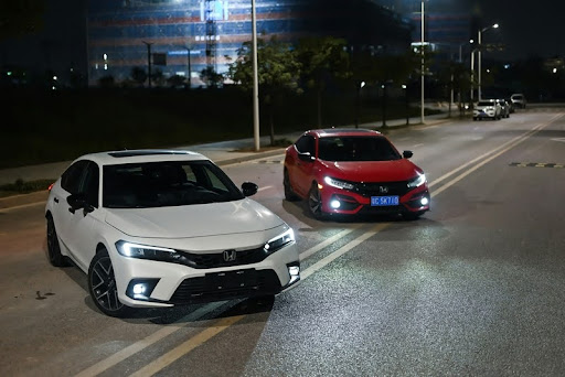 Two parked cars, a Toyota and a Honda, side by side in a parking lot.