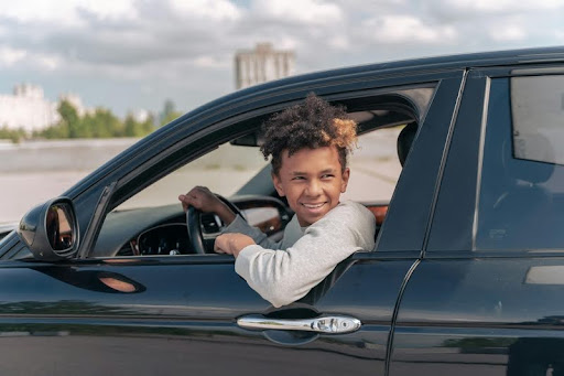 Teenager driving a car with both hands on the steering wheel