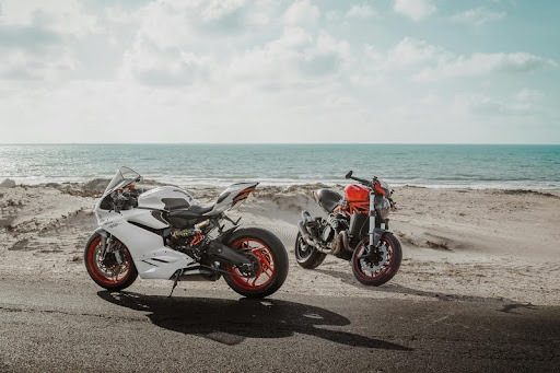 Motorcycle parked on a sandy beach near the ocean