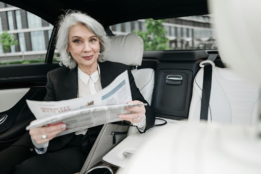 Woman reading a newspaper inside a parked car