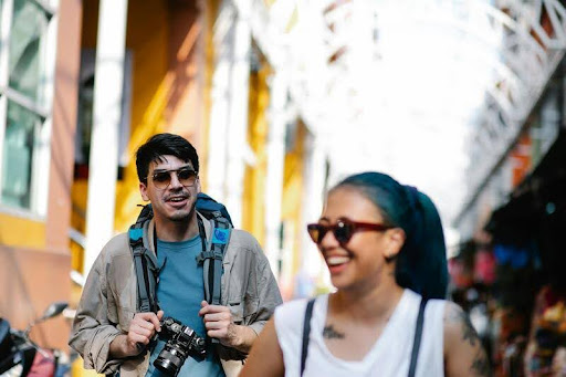 Man talking to a woman while holding a camera outdoors