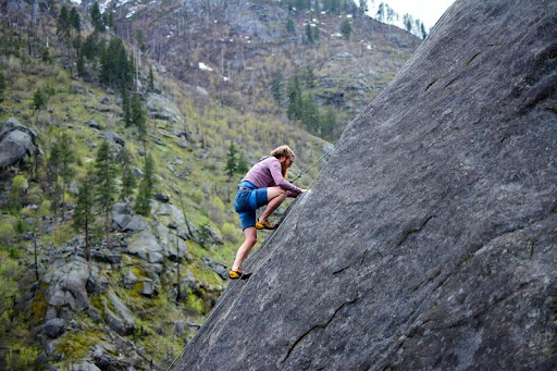 Man rock climbing on a mountain face under clear skies