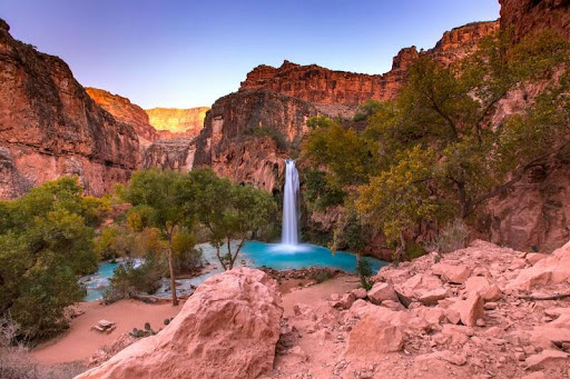 Turquoise waters of Havasu Creek flowing through red rock canyon in Arizona.