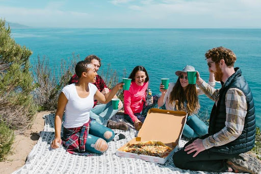 Friends sharing a meal together during a hiking break in nature