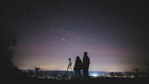 Couple lying on a blanket stargazing under a clear night sky