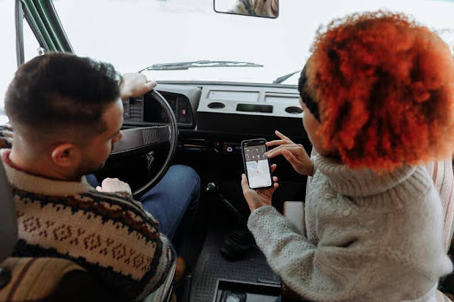 Couple using Google Maps on a smartphone while sitting in a car