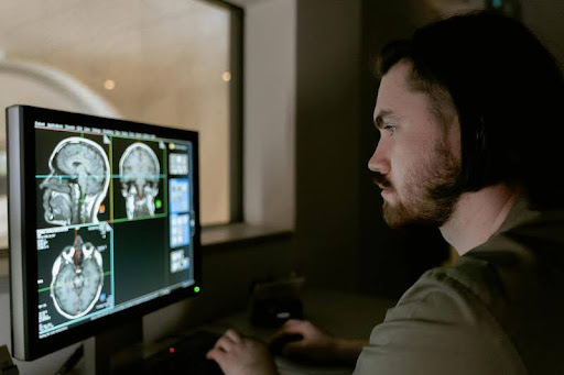 Person analyzing brain activity data on a computer screen.