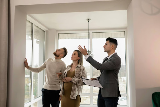 People inspecting a house exterior with a clipboard and checklist