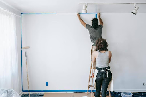 Person on ladder repairing the exterior of a house