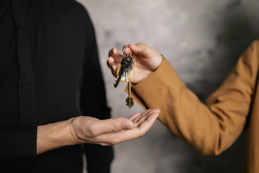 Person handing over a bundle of keys to another person