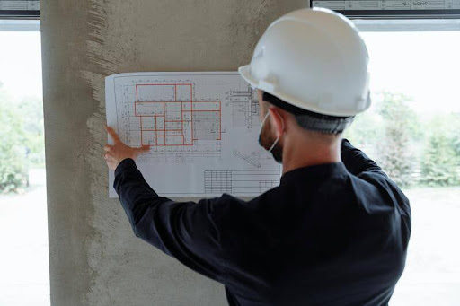 Engineer holding a floor plan at a construction site