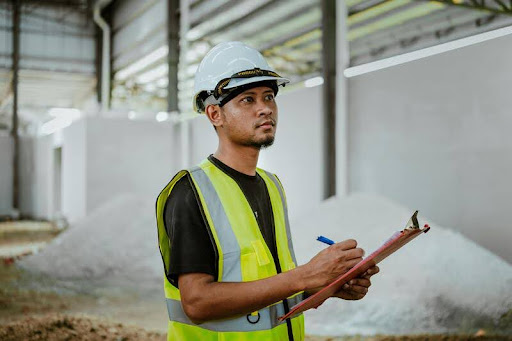 Construction inspector examining a building site with a clipboard