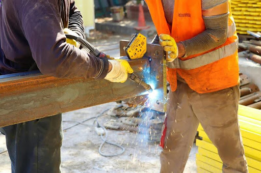 Construction workers wearing safety helmets, vests, and gloves at a jobsite