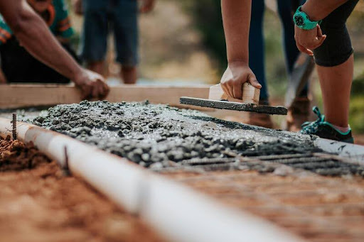 Workers pouring concrete for a building foundation