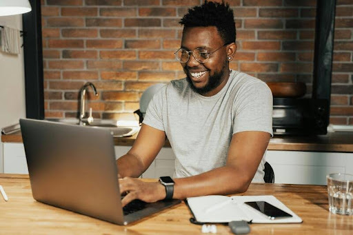 Man sitting on a couch using a laptop at home