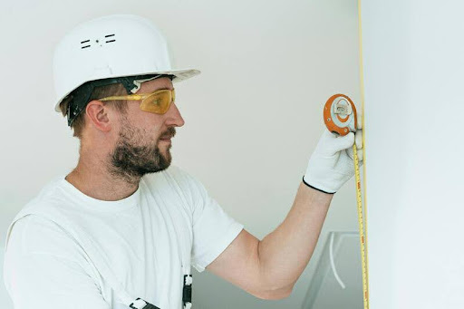Man holding a measuring tape during a home renovation project