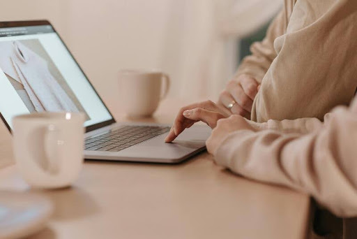 Two people reviewing information on a laptop in an office setting