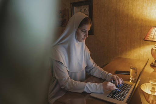 Woman using a laptop at home, working from her home office