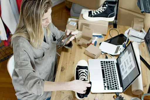 Woman working on a laptop at a desk in a bright office setting