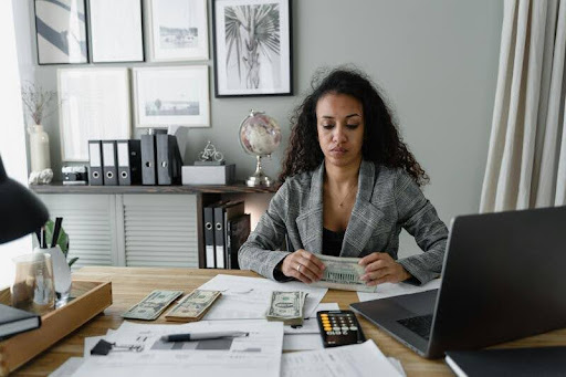 Woman holding several U.S. dollar bills