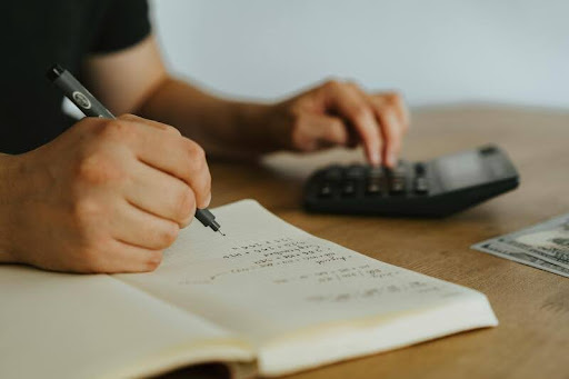 Man doing calculations with a calculator and paperwork