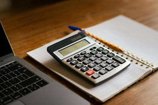 Calculator and laptop on a table used for financial planning
