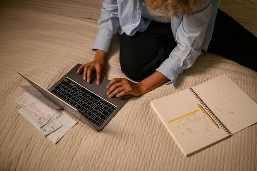 Woman reviewing her paycheck while using a laptop