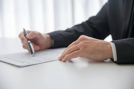 Person holding a pen and reviewing a financial planning document