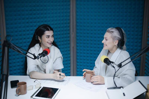 Woman conducting an interview with a guest in a studio setting.
