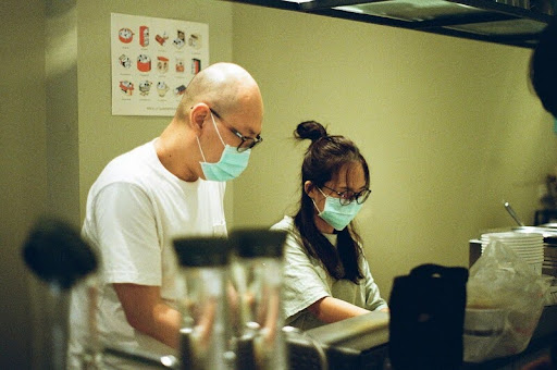 Doctor and nurse wearing masks in a hospital hallway.