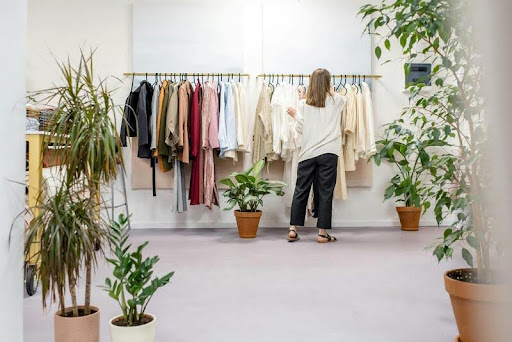 Businesswoman in a clothing shop assisting a customer with apparel.