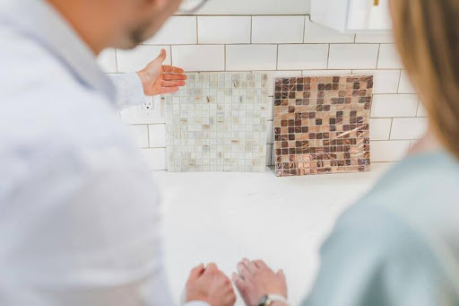 Man presenting tile samples to another person.