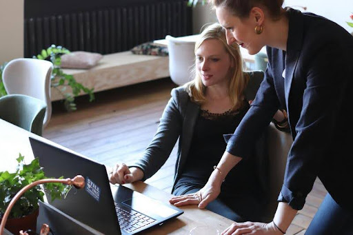 Woman talking to a colleague while working at a desk