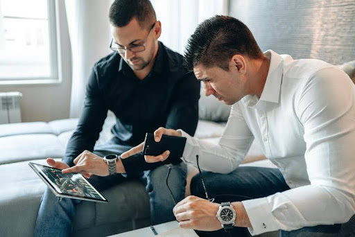 Two men reviewing investment data on a tablet