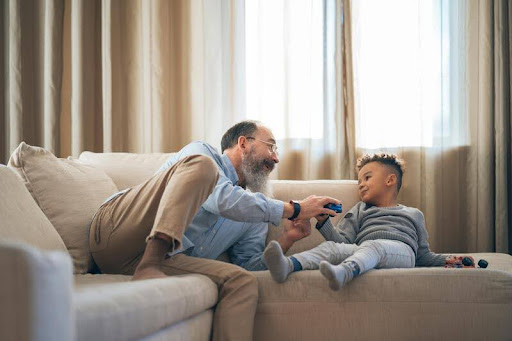 Father and son sitting together on a living room couch
