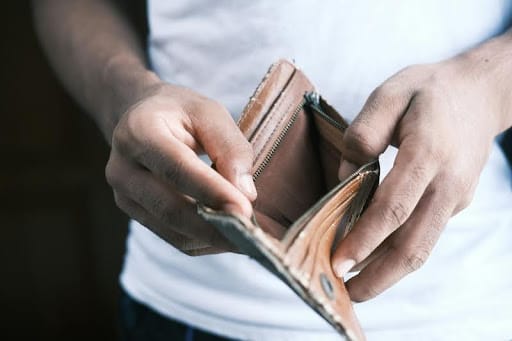 Person holding a brown leather wallet
