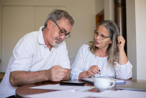 Couple sitting together, appearing thoughtful and concerned