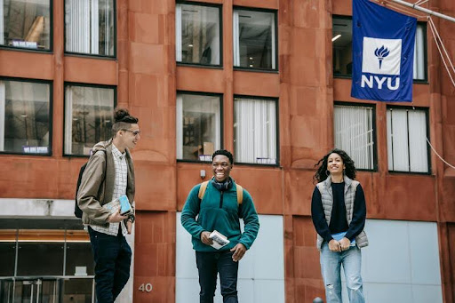 Students sitting with textbooks, studying together on campus.