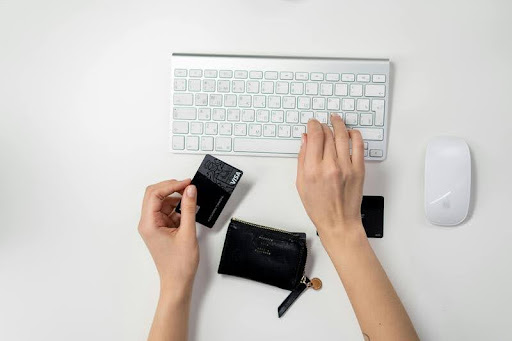 Woman holding a credit card while using a laptop